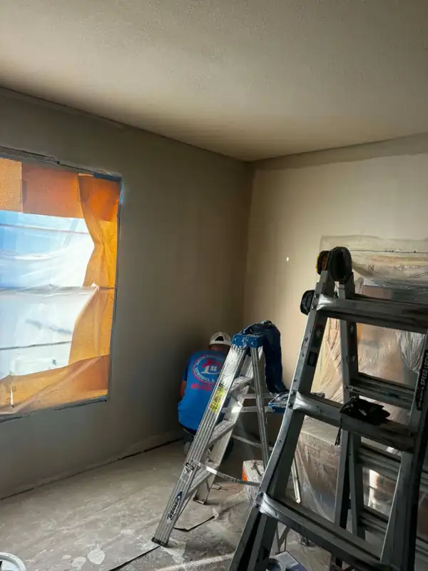 Crew working on drywall in a bedroom
