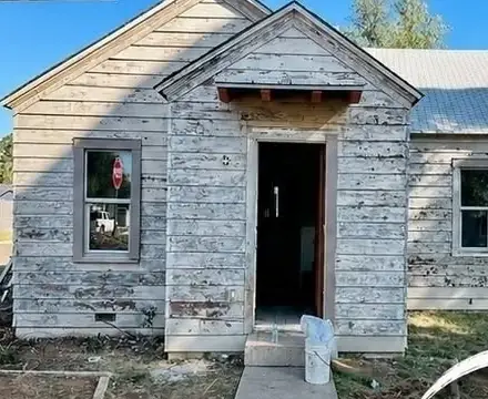 Before: run-down house with peeling siding and no door